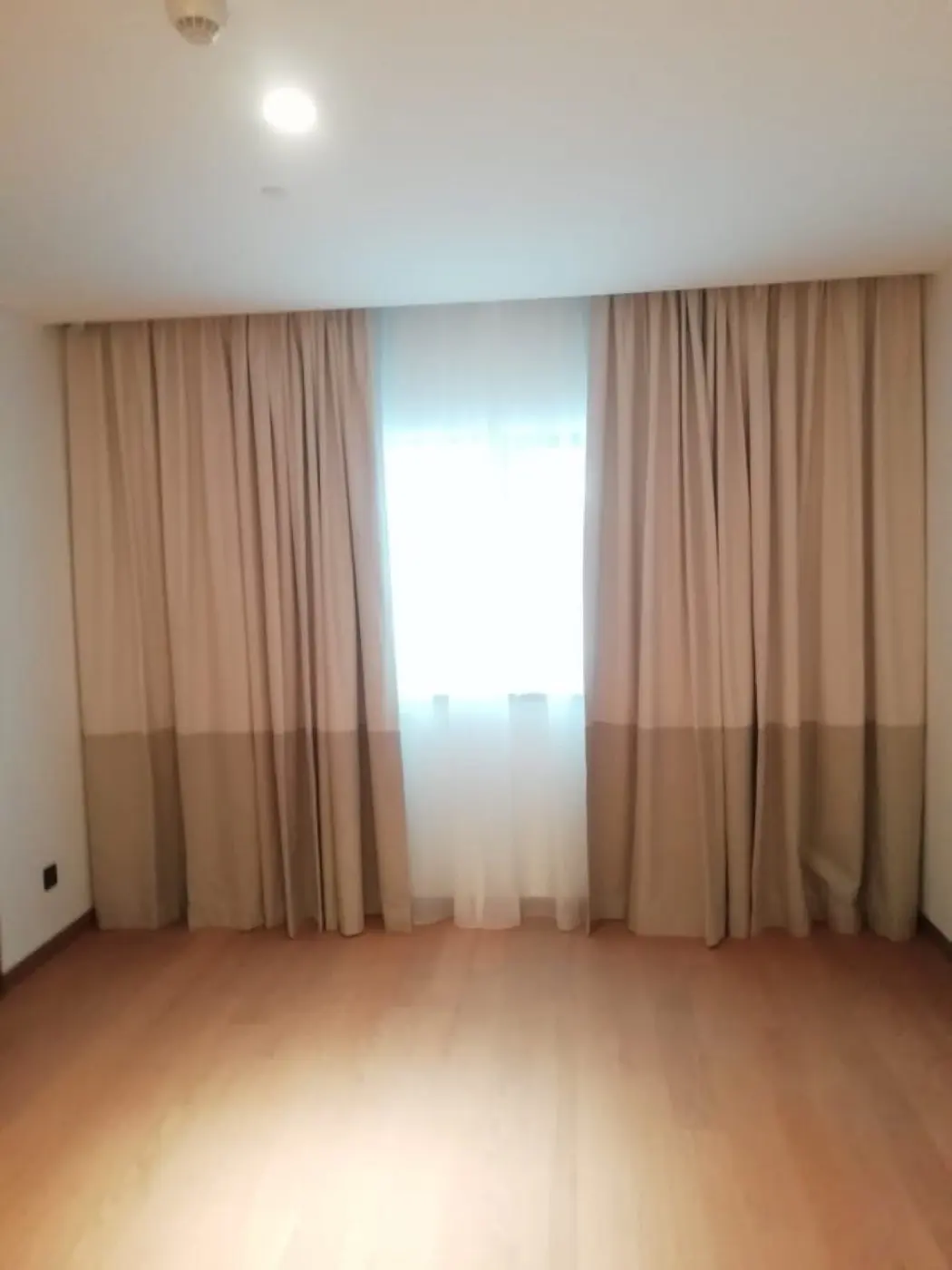 Double-layer sheer and blackout curtains in a Sharjah apartment